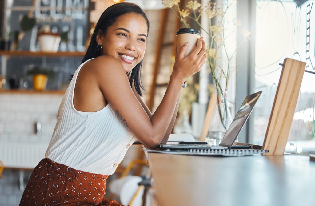 Happy woman relaxing in a coffee shop with a smile and thinking. Female enjoying relaxed day alone