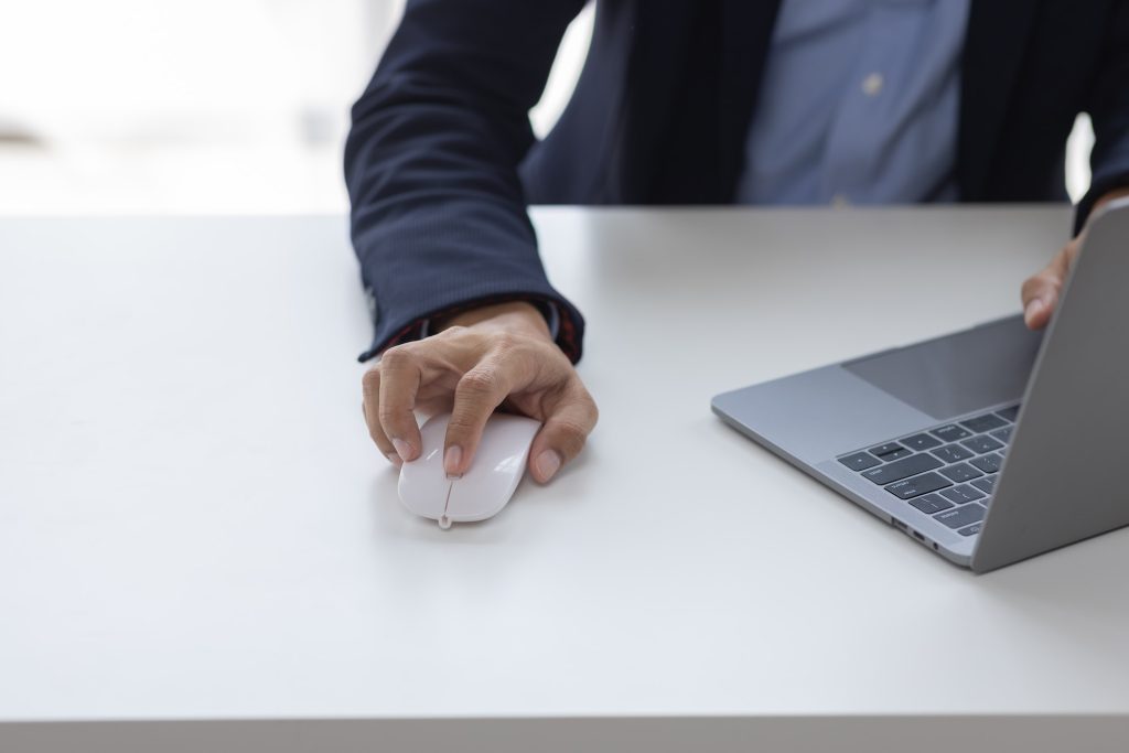 Image of Asian man hands clicking computer mouse