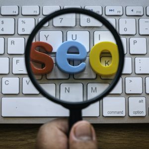 Search engine optimization concept. A hand holding magnifying glass magnify a word seo
