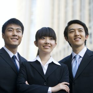 Three business professionals in front of skyscraper